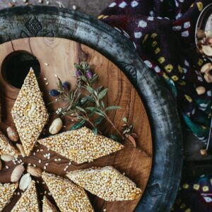 Hand-pounded gud tilkut, sesame and jaggery diamonds, on a wooden board