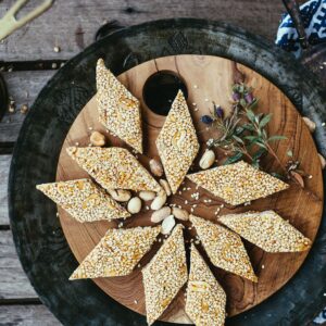 Sesame and jaggery tilkut pieces arranged in a star on dark wood
