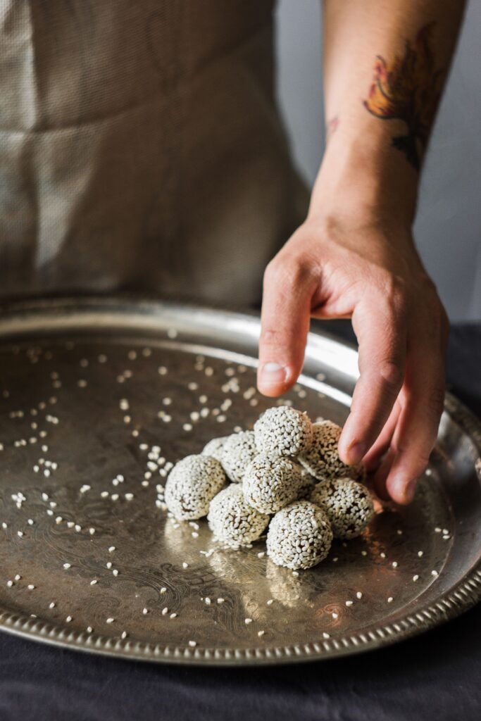 Roasted sesame sweet rounds piled on an engraved silver tray